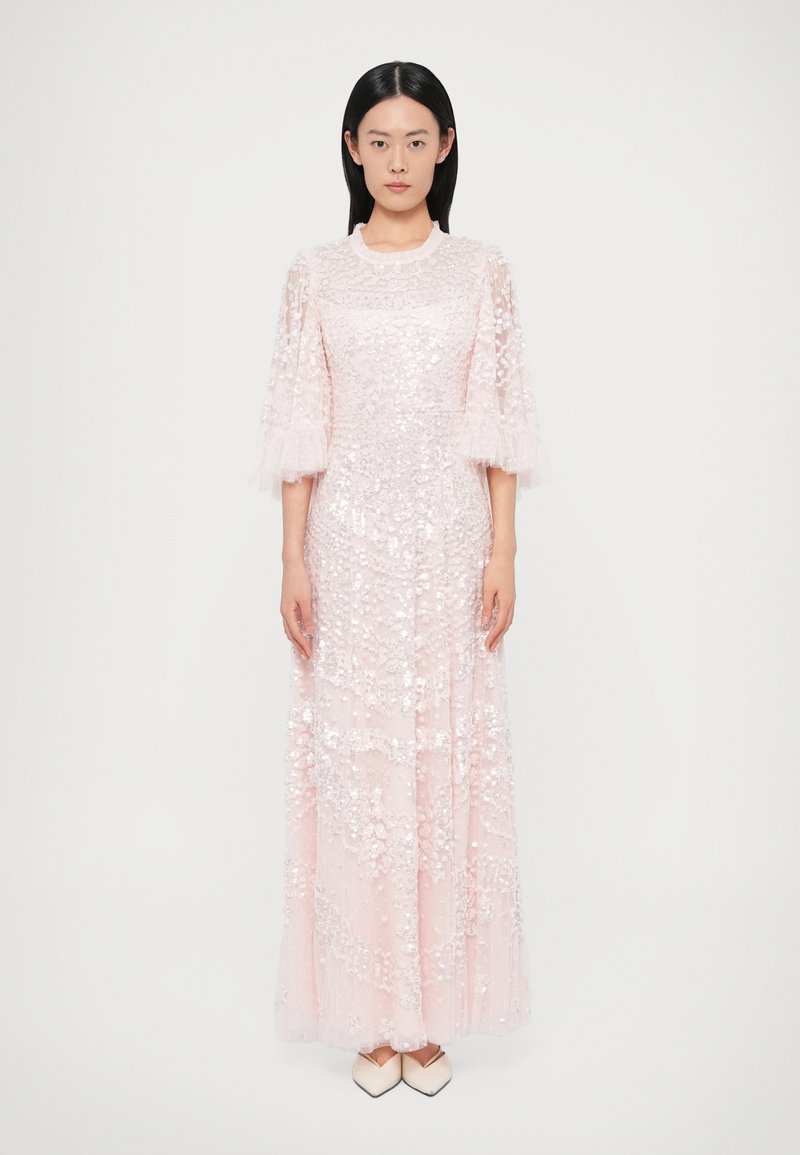 Rochie lungă roz cu paiete și mâneci din tul transparent, având un decolteu rotund și o siluetă fluidă. Material neted, texturat.