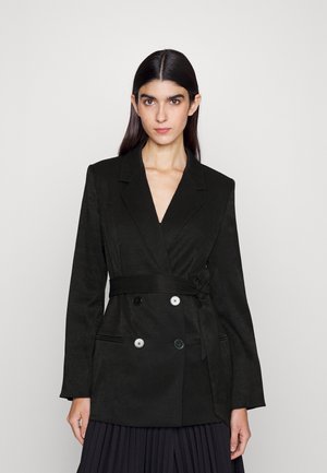 Black double-breasted blazer with a tie belt, made of textured fabric, featuring large white buttons and long sleeves.