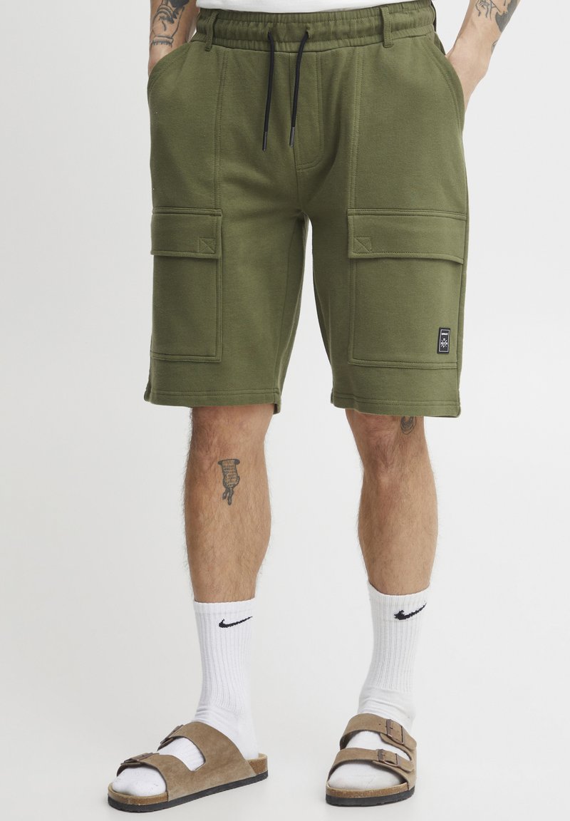 Olive green cargo shorts featuring an elastic waistband, two front pockets, and two side pockets, made of soft, textured fabric.