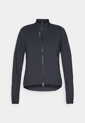 Melnā vieglā jaka ar augstu apkakli, priekšējo rāvējslēdzi, garām piedurknēm un nedaudz izliekts apakšmalu. Izgatavota no gludas, teksturētas auduma.