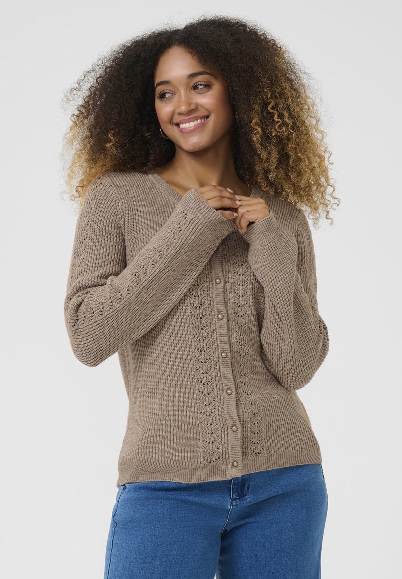 Brown ribbed cardigan with a V-neck, pearl buttons, and floral stitch accents on sleeves. Soft texture and relaxed fit.