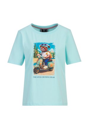 Chemise bleu clair à manches courtes avec un motif d'un ours portant des lunettes de protection et conduisant un scooter coloré, avec le texte "THE 19V69 CRUISING BEAR."