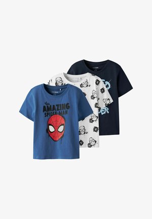 Trois T-shirts en bleu, blanc et marine. Le bleu est orné d'un graphique rouge de Spider-Man ; le blanc présente un design avec des éclaboussures noires ; le marine est uni.