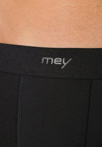 Caleçons pour hommes noirs avec une ceinture élastique texturée portant le logo "mey" en argent près du haut, conçus pour le confort et l'ajustement.