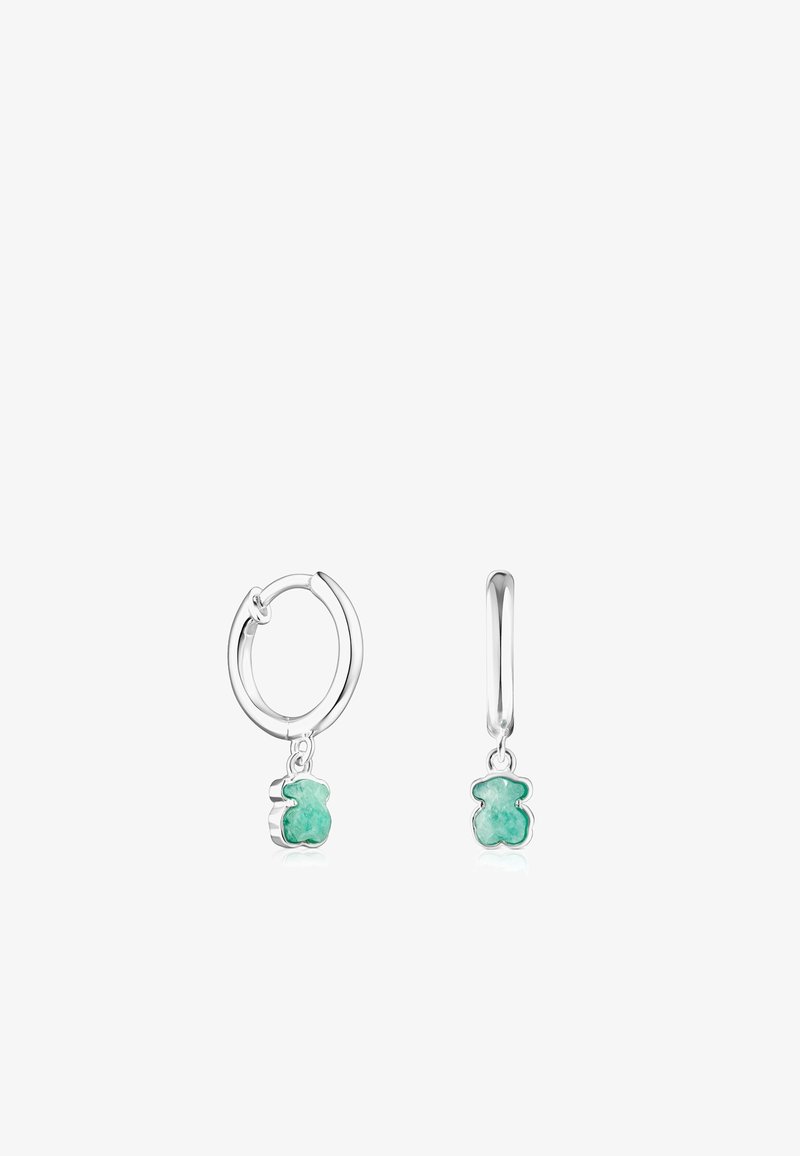 Pendientes de aro de plata que cuentan con un charm en forma de oso transparente de color verde, detallado con una textura suave y un acabado pulido.