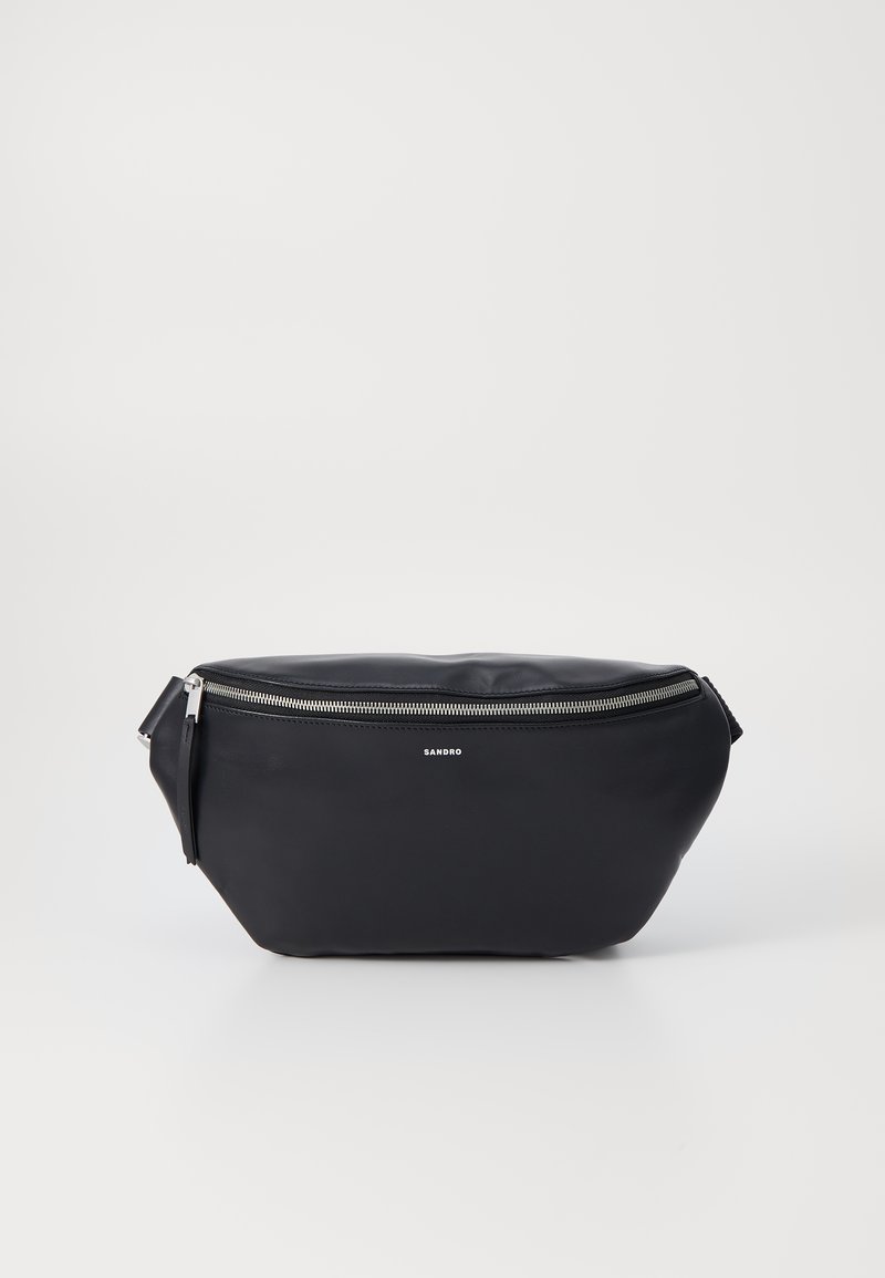 Sac en cuir noir en bandoulière avec une forme arrondie, fermeture éclair argentée et accessoires en métal. Présente un logo sur le devant et une sangle ajustable.