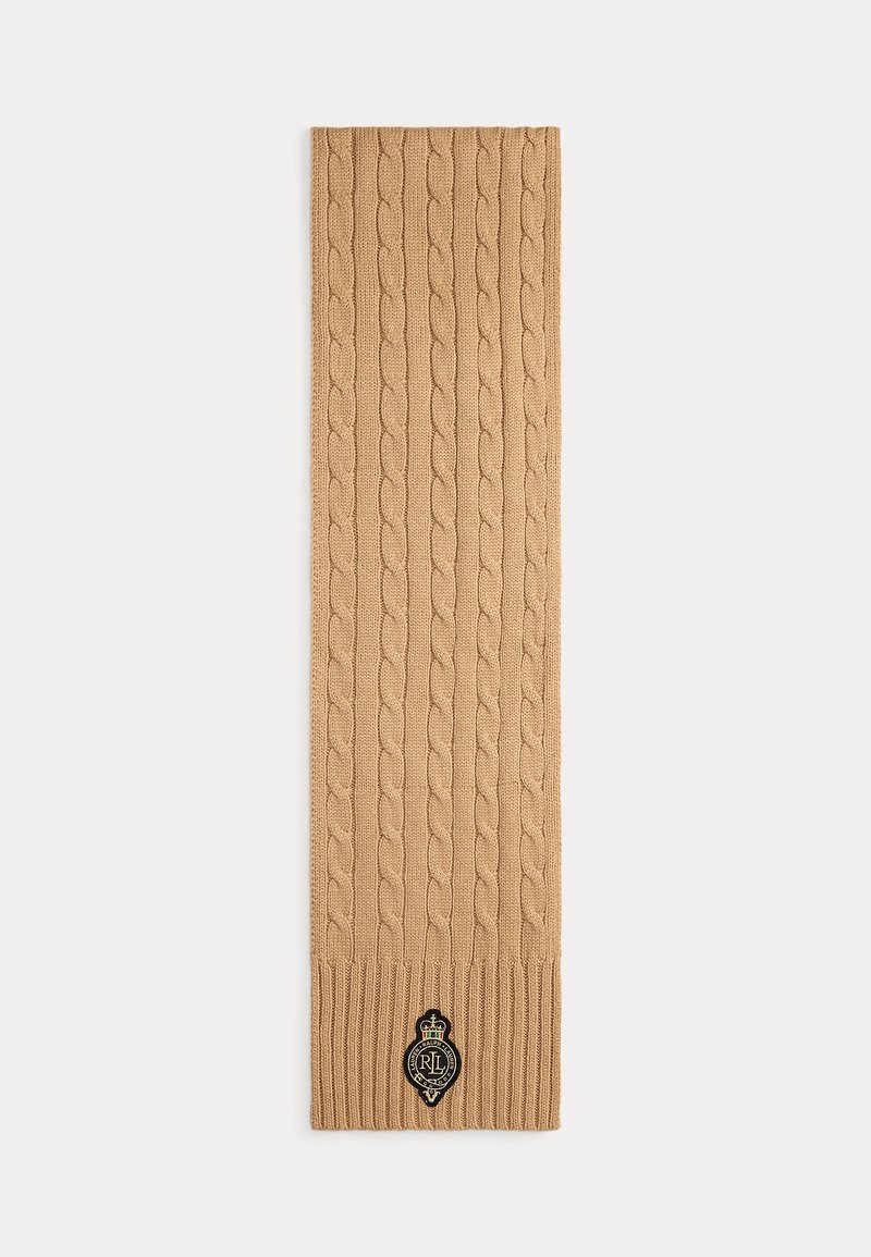 Sciarpa beige a maglia cable-knit con estremità a coste. Presenta una patch con logo nero che mostra una corona e le iniziali. Texture morbida e forma allungata.