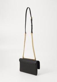 Black leather handbag with a textured finish, featuring a fold-over flap, a long adjustable chain strap, and gold hardware accents.