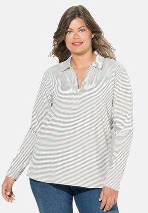 Langærmet polo-shirt i lys creme med tynde brune striber. Har krave og en halvmeter-knaplukning. Blødt stof og afslappet pasform.