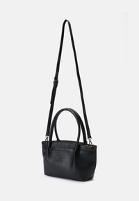 Black leather handbag featuring a textured finish, dual top handles, and a detachable adjustable shoulder strap. Minimalist design with a solid color.