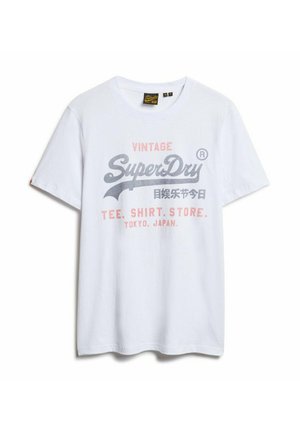 T-shirt bianco in cotone con stampa grafica grigia e rosa. Il design include il testo "Vintage SuperDry" e dettagli da Tokyo, Giappone.