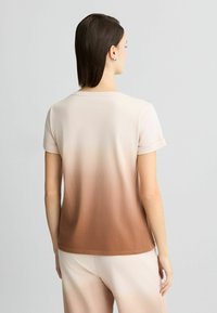 Short-sleeved t-shirt in gradient beige to brown, crew neck, soft cotton material, with rolled sleeves and a relaxed fit.
