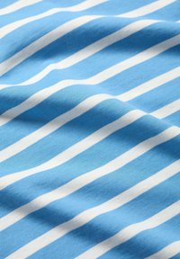 Bomullstyg med blå och vita horisontella ränder. Mjuk textur, måttlig stretch och tydlig färgkontrast mellan ränderna.