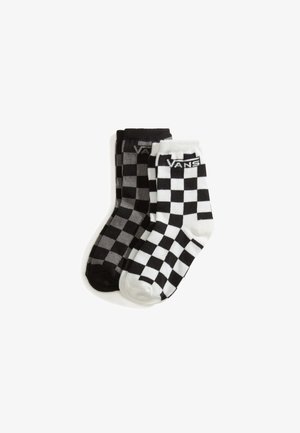 Dwie pary skarpetek Vans typu crew z czarno-białym wzorem w kratkę, jedna para biała z czarnymi kwadratami, druga czarna z szarymi kwadratami.