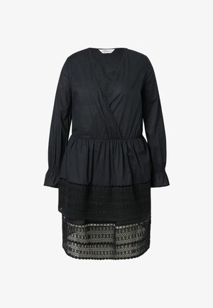 Musta mekko, jossa on pitkät hihat, syvä V-pääntie, pleatattu vyötärö ja kerrokselliset pitsikoristeet helmassa. Valmistettu kevyestä kankaasta.