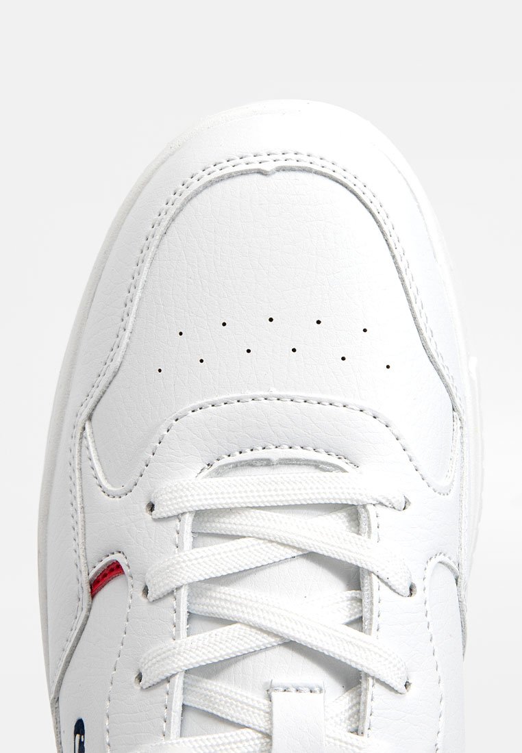 Weißer Sneakers aus strukturiertem Leder, mit abgerundeter Zehenpartie, dunklen Perforationen zur Belüftung und akzentuiert mit einem kleinen roten Detail.