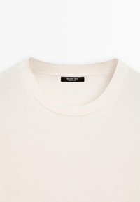 Helle Cremefarbene Pullover mit Rundhalsausschnitt, gerippten Bündchen und Saum, aus weichem Strickmaterial. Das Etikett trägt die Aufschrift "Massimo Dutti."