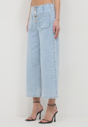 Hellblaue Schlagjeans mit hoher Taille, drei Knopfverschlüssen und zwei Gesäßtaschen. Der Stoff hat eine weiche Denim-Textur.