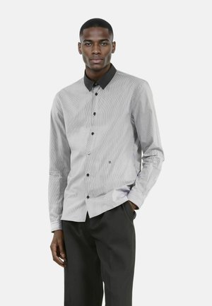 Grijs en witte gestreepte button-up shirt met een zwarte kraag, met lange mouwen, zwarte knopen en een klein logo-detail aan de onderkant vooraan.