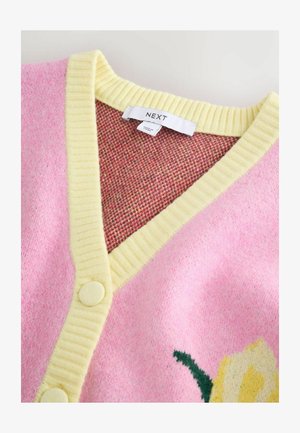 Różowy kardigan z żółtym prążkowanym wykończeniem i guzikami, ozdobiony kwiatowym wzorem. Tkanina ma miękką fakturę, a wnętrze w kratkę.