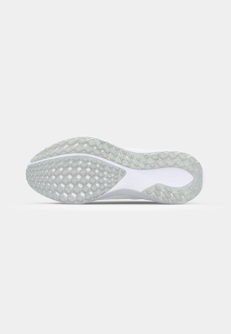 Suela de zapato con una superficie de goma texturizada, que presenta un patrón de diamante y un contorno curvado. Predominantemente blanca con detalles en gris claro.