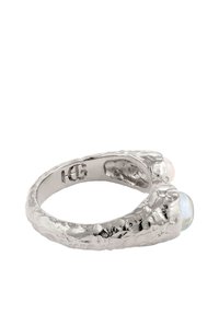 Sömmring med en texturerad finish, med två rundade stenar, en rosa och en blå, i varje ände, öppen stil.