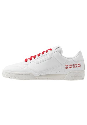 Witte Adidas-sneaker met rode veters en rode tekst op de hiel met de woorden "Alleen deze schoen zal de planeet niet redden."