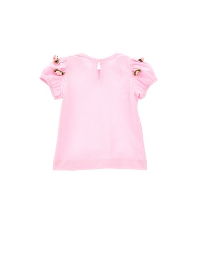 T-shirt in cotone rosa con maniche a sbuffo corte, adornato con dettagli floreali sulle spalle e un'apertura a chiave sul retro. Texture liscia.