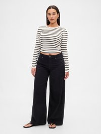 Prugasti dugih rukava uski kroj u krem boji i crnoj. Labave crne široke traperice, nosi se s ravnim crnim japankama.