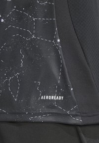 Juodas sportinis audinys su žvaigždžių konstelacijos raštu, išmargintu brūkšniais, papuoštas balta "AEROREADY" logotipu.