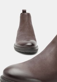 Prunad nahkflexi kingad sileda viimistlusega, ümarate varvastega ja elastsete külgpaneelidega. Omab tugevat kummist tallat.