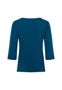 Top blu teal con maniche a tre quarti e scollatura ampia a forma quadrata. Realizzato in tessuto morbido con vestibilità comoda e senza hardware visibile.