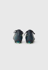 Black soccer cleats with a textured upper, green accents, and spiked soles. Features a streamlined design and secured with black laces.