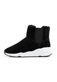Botines de ante negros con paneles laterales elásticos y una suela de goma blanca. Presentan un diseño limpio y una textura suave.