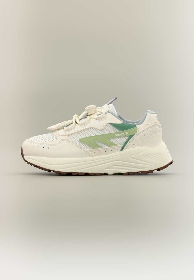 Fehér és világoszöld sportcipő hálós felsőrésszel, vastag talppal és húzózáras fűzőrögzítéssel, oldalnézetben semleges háttér előtt.