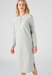 Vestito da notte grigio a maniche lunghe con collo henley, dotato di una tasca decorata con punti bianchi e una fessura laterale per facilitare i movimenti.