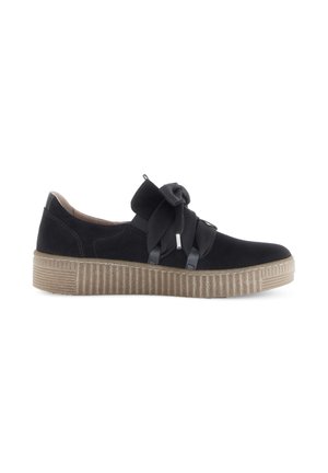 Zwarte suède sneaker met een gematteerde rubberen zool, voorzien van kruislings elastische banden en een strakke, lage profielontwerp.