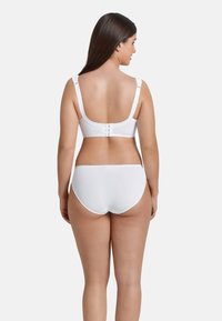 Set di reggiseno e mutandine bianche, in cotone, con spalline regolabili, chiusura con gancio e occhiello sul retro, texture liscia, design semplice.