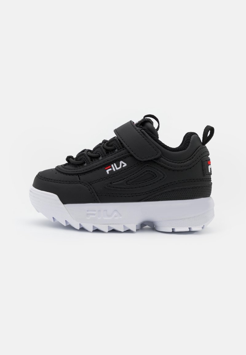Baskets FILA noires avec une semelle blanche épaisse à rainures, fermeture à lacets à l'avant et une seule bande velcro, logo sur le côté et languette de tirage au talon.