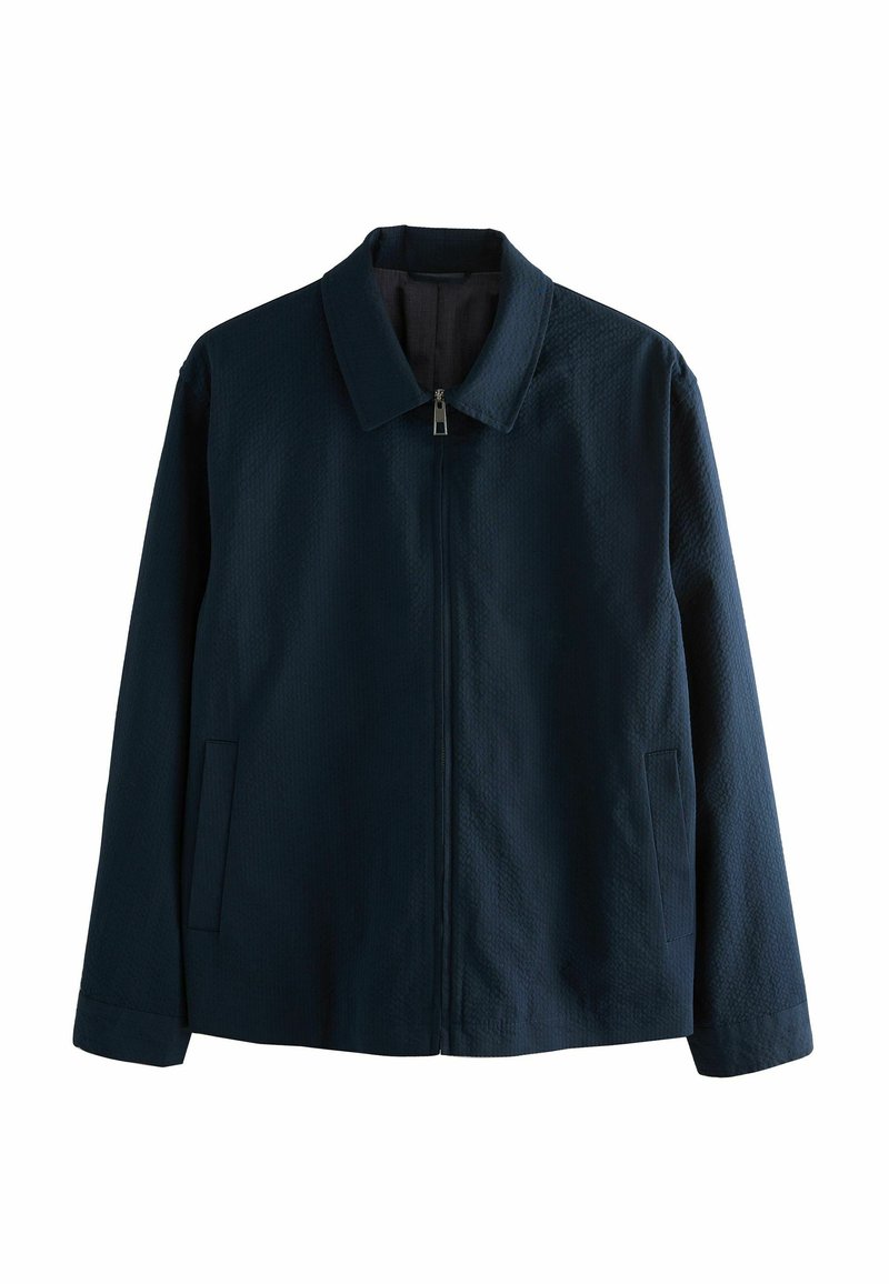 Chaqueta azul marino con un tejido texturizado, con cuello, cremallera frontal y dos bolsillos laterales.