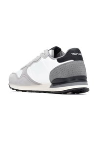 Zapatilla con parte superior de cuero blanco y acentos de ante gris, talón texturizado negro y suela de goma. Detalles de perforación sutil en la parte trasera.