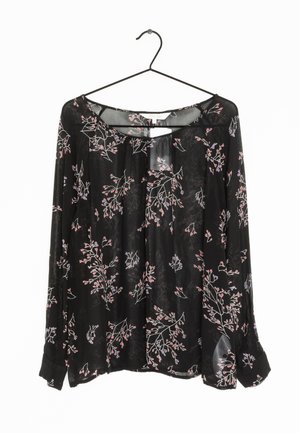 Blouse noire à manches longues, ornée d'un motif floral en rose et violet. Fabriquée dans un tissu léger et transparent avec une coupe décontractée.