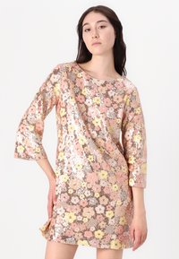 Abito di paillettes con motivo floreale nei colori rosa, giallo e argento. Presenta maniche a tre quarti e un collo rotondo. Superficie testurizzata.