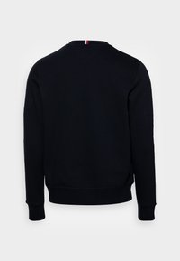 Felpa nera con colletto tondo e polsini a costine. Sul retro presenta un sottile accento tricolore sul colletto. Tessuto morbido.