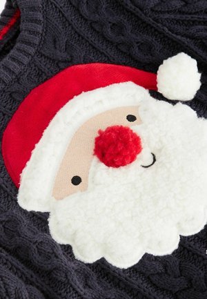 Gros plan sur un pull sombre tricoté avec un visage de Père Noël texturé, comprenant un chapeau rouge, un nez rond rouge, une barbe blanche duveteuse et un pompon.