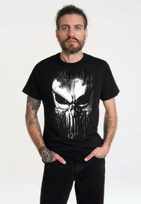 Black cotton t-shirt featuring a white skull graphic with vertical streaks. Short sleeves, crew neck, casual fit, smooth texture.