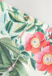 Blommig tyg med stora röda blommor med gula mittpunkter, gröna blad och detaljerade botaniska illustrationer på en vit bakgrund.