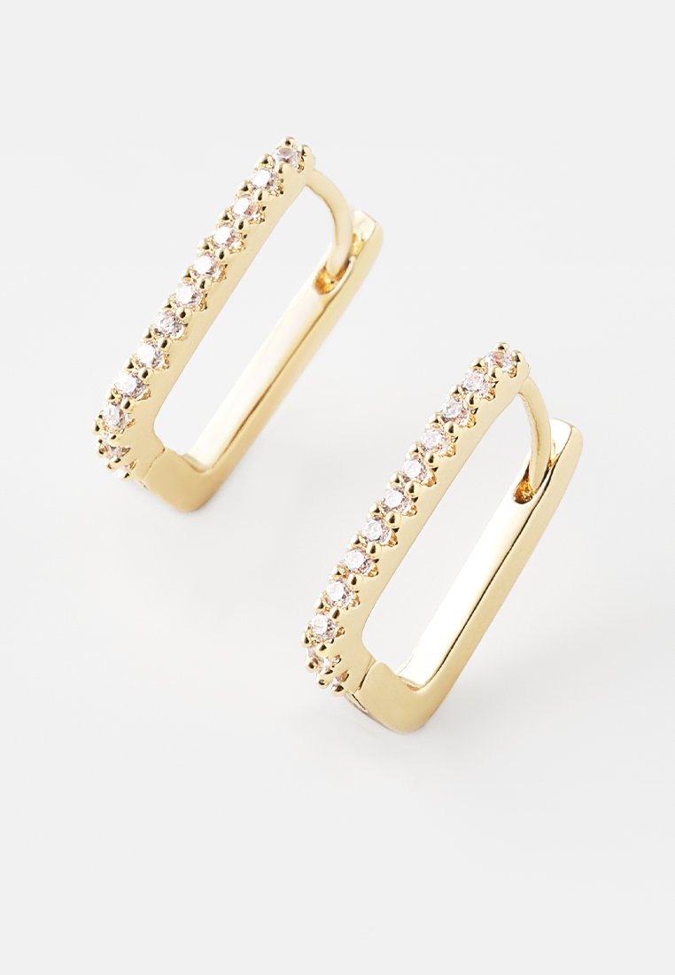 Boucles d'oreilles rectangulaires en or avec une rangée de rhinestones clairs le long du bord, surface métallique lisse et design en forme de créole ouverte.