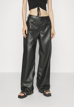 High-waisted black leather wide-leg pants with a smooth texture, button closure, and belt loops. Worn with a cropped top and sandals.
