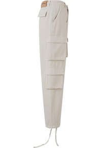 Pantalones cargo beige con múltiples bolsillos laterales, una cintura ajustada y puños regulables con cordón. Fabricados con un material de algodón duradero y de textura lisa.